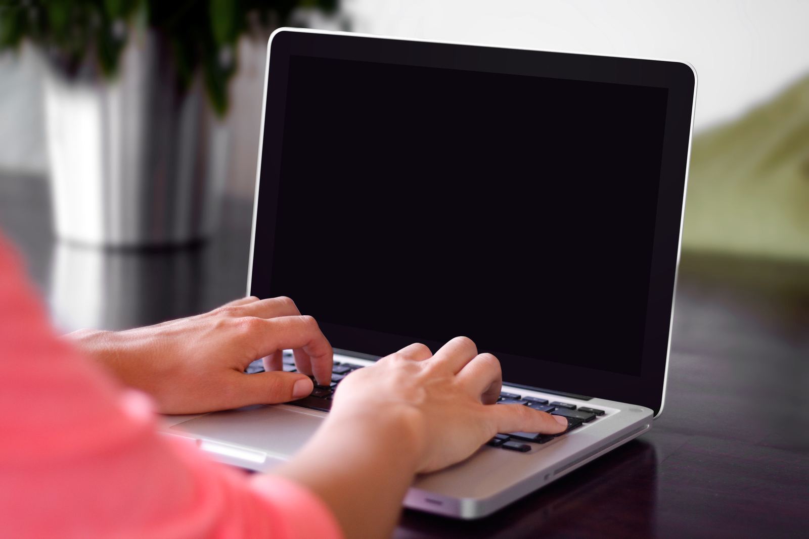 Hands typing on a laptop keyboard